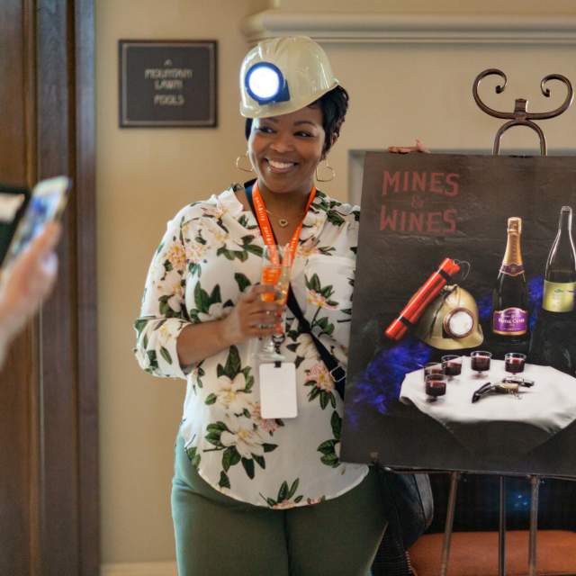 Woman next to a painting of wine