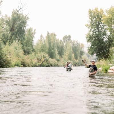 man in foreground fly fishing