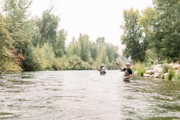 man in foreground fly fishing