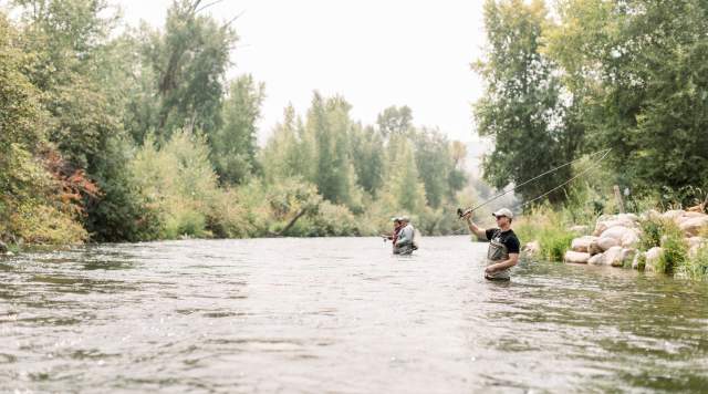 man in foreground fly fishing