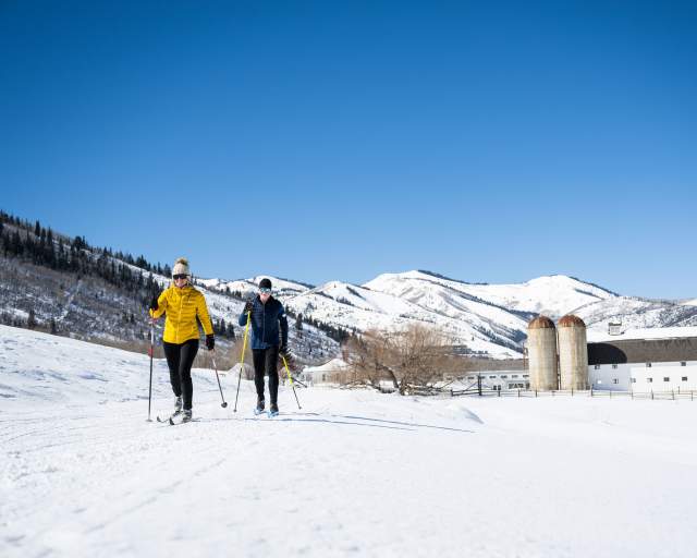 Man and Women Nordic Skiing on a bluebird day at Park City Nordic Center Man and Woman Nordic Skiing on a bluebird day at the white pine nordic center.