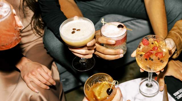 group of people holding a round of drinks