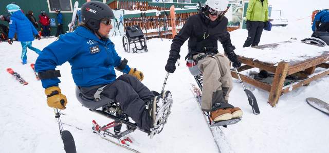 an instructor giving an adaptive ski lesson