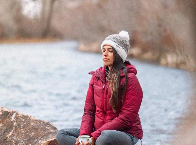 Woman sitting by a river