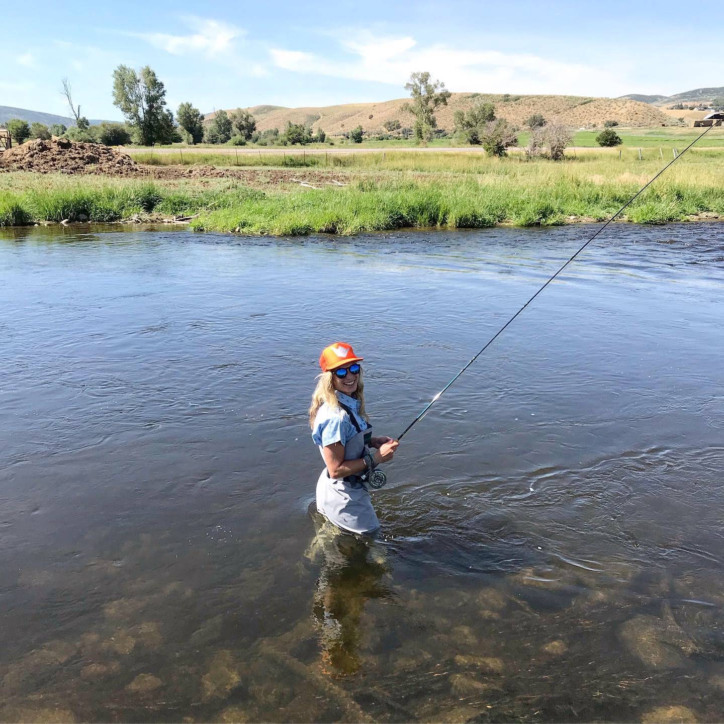 Person Standing in the river with fishing pole