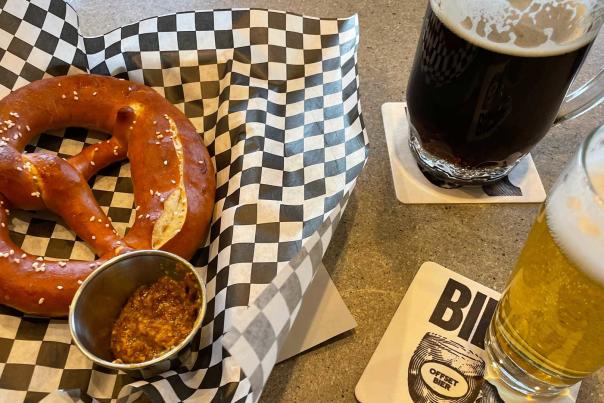 Two beers and a bavarian pretzel sit on a counter at a bar in Park City, UT