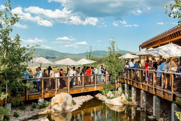 People on the deck of Blue Sky Ranch enjoying drinks and appetizers