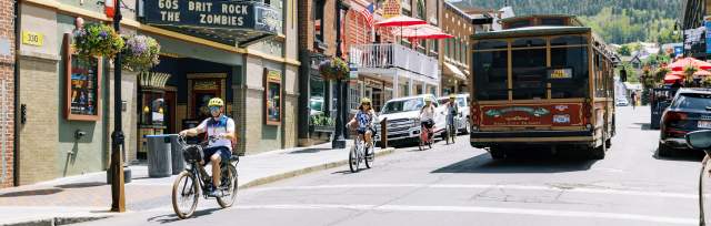 group riding bikes down main street passing the trolly