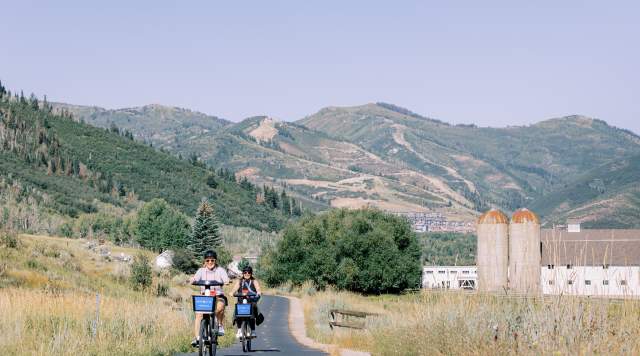 Two people riding summit bike share