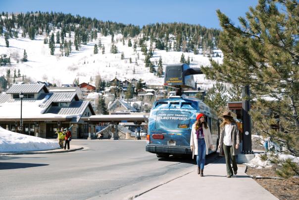 Girls walking past electric bus at Old Town transit Center