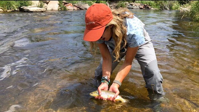 Person holding fish after catching it in the river