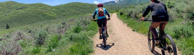 Two mountain bikers riding a dirt path