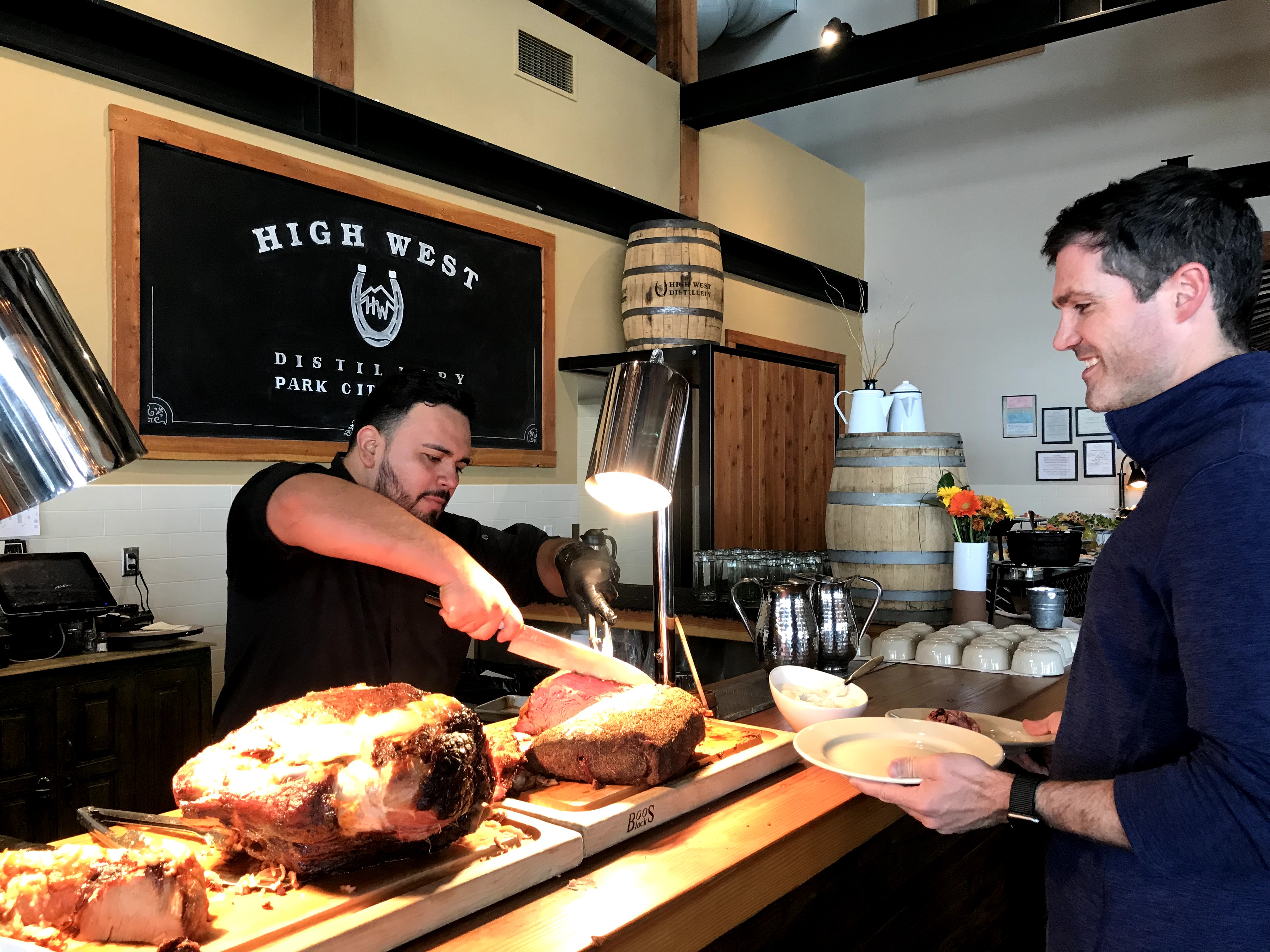 a guy serving another person at a brunch meat carving station