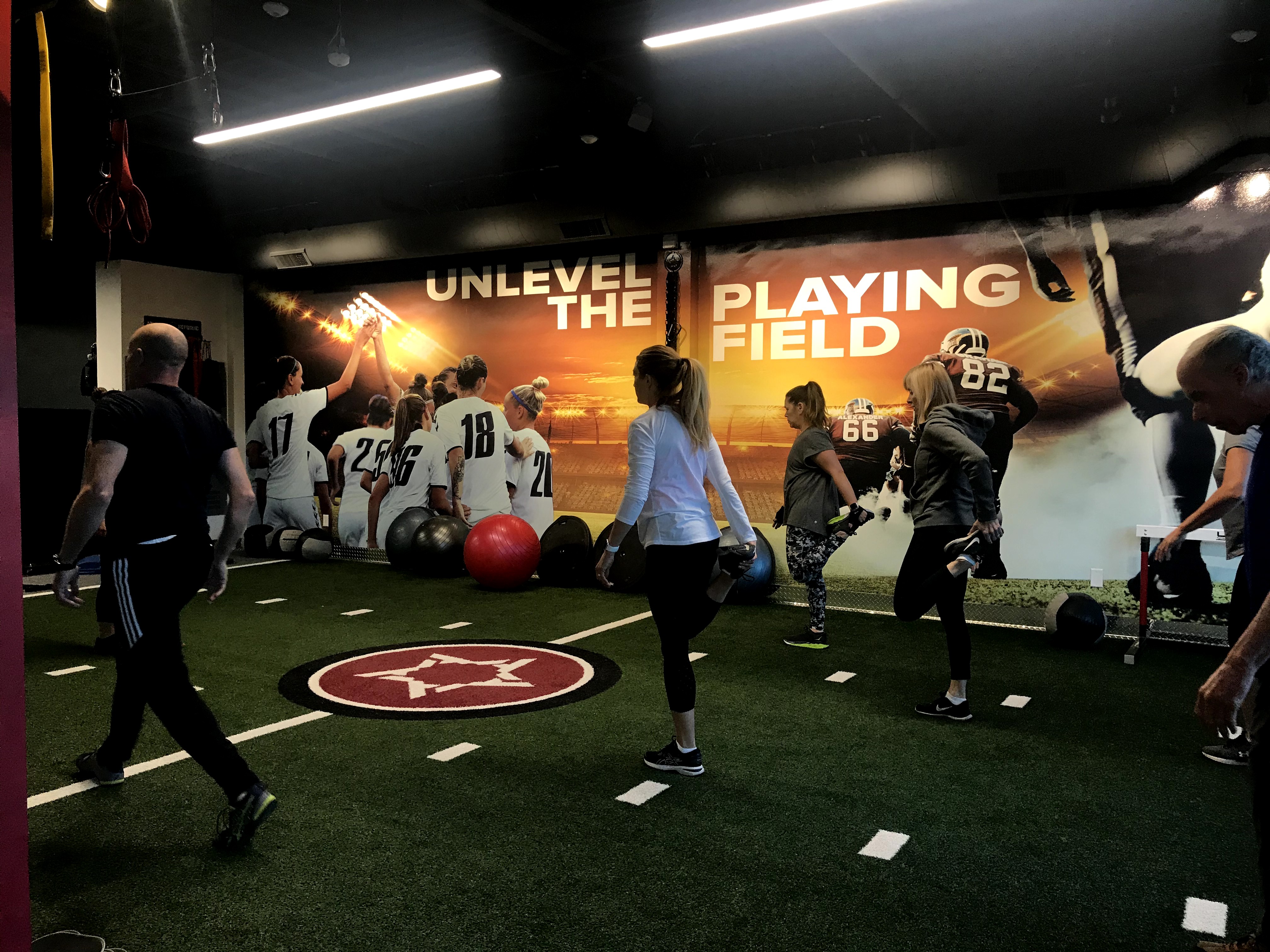 A group of people doing warm up exercises together in a Gym