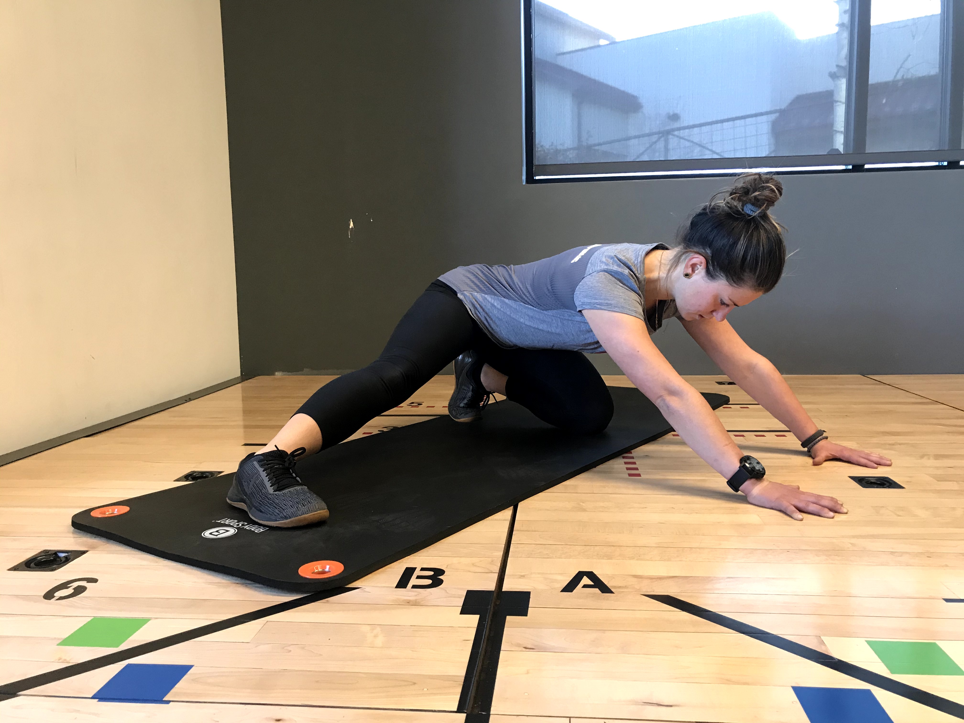 Instructor demonstrating "Adductor (inner thigh) rock back" exercise