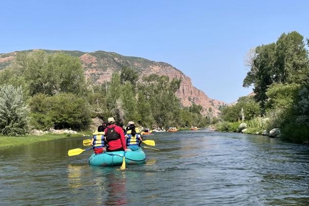 People in rafts floating down a river in a line