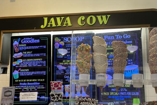 Waffle cones in front of Java Cow sign and menu