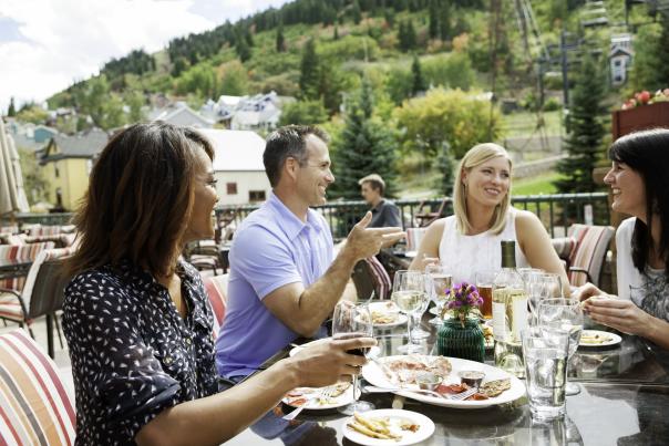 Group of adults eating lunch on patio near town lift in the summer