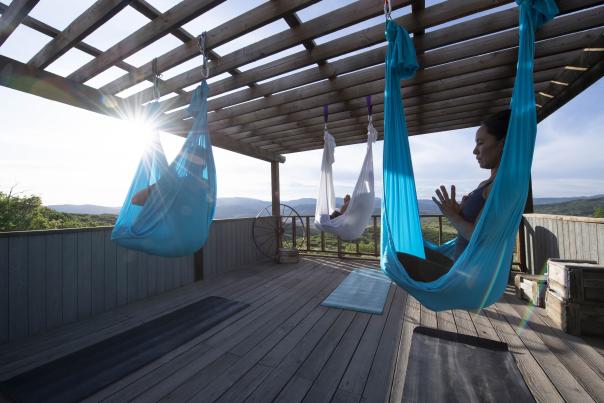 Three women sitting in silks during a yoga practice