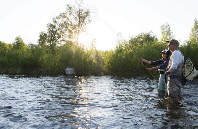 Man and woman fly fishing in the summer on the Provo River.