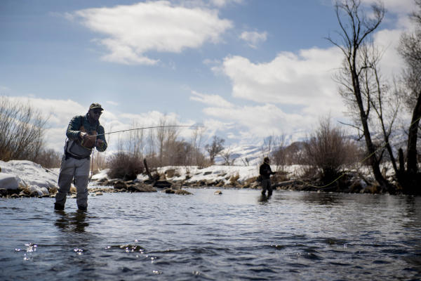 Two people fly fishing in the winter