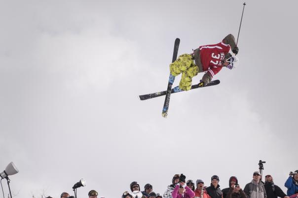 Skier getting big air in a halfpipe over a crowd