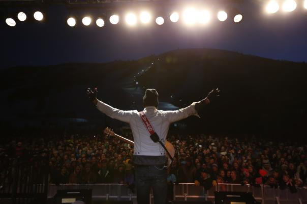 Singer performs in front of crowd at night concert