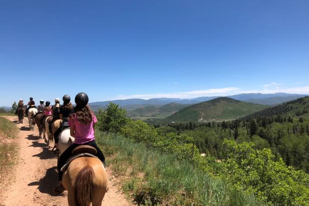 Group of people on horseback with mountain's in background