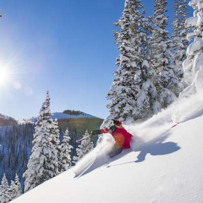 Skier with scenic view of sun and blue skies in background