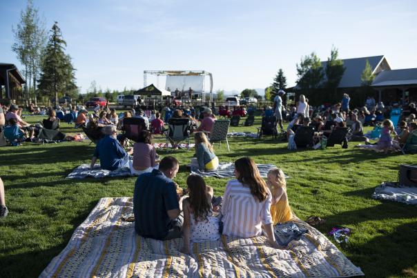 Family on picnic blanket during summer concert at High Star Ranch.