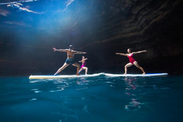 Three women doing yoga on stand up paddleboards in a crater near Park City, UT