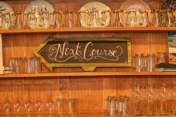 Glassware and a sign that reads Next Course